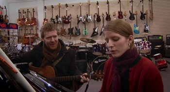 Movie still from “Once” (2007), directed by John Carney – A man and a woman playing a guitar in a music store; Medium shot, Over the shoulder angle