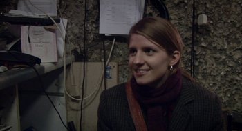 Movie still from “Once” (2007), directed by John Carney – A woman in a jacket and scarf smiling for the camera; Close Up shot, Over the shoulder angle