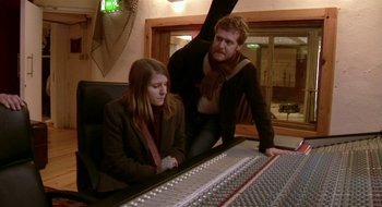 Movie still from “Once” (2007), directed by John Carney – A man and a woman sitting in front of a sound board; Medium shot, High angle