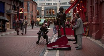 Movie still from “Once” (2007), directed by John Carney – A group of people standing on the side of the street; Wide shot, High angle