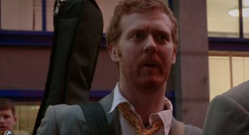 Movie still from “Once” (2007), directed by John Carney – A person wearing a suit and tie; Close Up shot, Over the shoulder angle