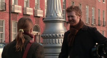 Movie still from “Once” (2007), directed by John Carney – A man and a woman standing in front of a building; Medium shot, Over the shoulder angle