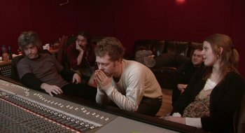 Movie still from “Once” (2007), directed by John Carney – A group of people sitting around a sound board; Medium shot, High angle