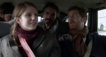 Movie still from “Once” (2007), directed by John Carney – A man and two women in the back seat of a car; Close Up shot, Over the shoulder angle