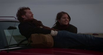 Movie still from “Once” (2007), directed by John Carney – A man and a woman sitting on top of a car; Medium shot, Low angle