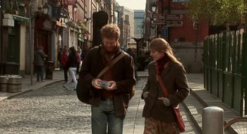 Movie still from “Once” (2007), directed by John Carney – A man and a woman walking down a street; Medium shot, Over the shoulder angle