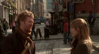Movie still from “Once” (2007), directed by John Carney – A man and a woman standing on a sidewalk; Medium shot, Over the shoulder angle