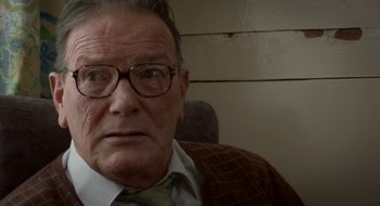 Movie still from “Once” (2007), directed by John Carney – An older man wearing a suit and tie; Close Up shot, Over the shoulder angle