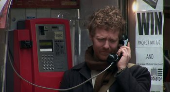 Movie still from “Once” (2007), directed by John Carney – A man talking on a phone while wearing a scarf; Close Up shot, High angle