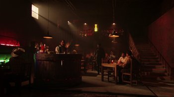 Movie still from “Once Upon a Time in Mexico” (2003), directed by Robert Rodriguez – People are sitting at a bar in a dark room; Wide shot, Low angle
