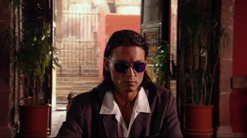 Movie still from “Once Upon a Time in Mexico” (2003), directed by Robert Rodriguez – A man with long black hair wearing sunglasses; Medium shot, Low angle