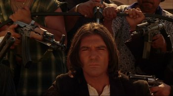 Movie still from “Once Upon a Time in Mexico” (2003), directed by Robert Rodriguez – A man with long brown hair is getting his hair combed; Close Up shot, Over the shoulder angle