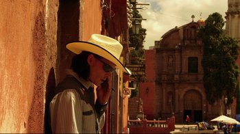 Movie still from “Once Upon a Time in Mexico” (2003), directed by Robert Rodriguez – A man wearing a cowboy hat while talking on a cell phone; Medium shot, Low angle