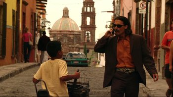 Movie still from “Once Upon a Time in Mexico” (2003), directed by Robert Rodriguez – A man talking on a cell phone while standing next to another man; Medium shot, Low angle