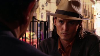 Movie still from “Once Upon a Time in Mexico” (2003), directed by Robert Rodriguez – A man wearing a hat talking to another man in front of him; Close Up shot, Over the shoulder angle