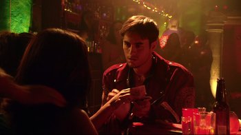 Movie still from “Once Upon a Time in Mexico” (2003), directed by Robert Rodriguez – A man sitting in front of a woman at a bar; Medium shot, Over the shoulder angle