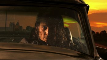 Movie still from “Once Upon a Time in Mexico” (2003), directed by Robert Rodriguez – A man sitting in the driver's seat of a car; Close Up shot, Low angle