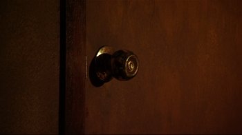 Movie still from “Once Upon a Time in Mexico” (2003), directed by Robert Rodriguez – A door knob on a wooden door; Extreme Close Up shot, Overhead angle