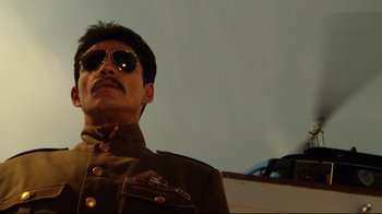 Movie still from “Once Upon a Time in Mexico” (2003), directed by Robert Rodriguez – A person wearing a uniform and wearing sunglasses; Close Up shot, Low angle