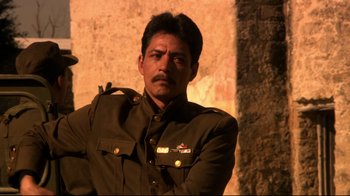 Movie still from “Once Upon a Time in Mexico” (2003), directed by Robert Rodriguez – A man in a military uniform standing in front of a wall; Close Up shot, Low angle