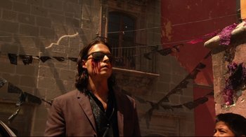 Movie still from “Once Upon a Time in Mexico” (2003), directed by Robert Rodriguez – A man in a suit and sunglasses with blood on his face; Medium shot, Low angle