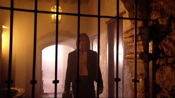 Movie still from “Once Upon a Time in Mexico” (2003), directed by Robert Rodriguez – A man standing behind bars in a jail cell; Wide shot, Low angle