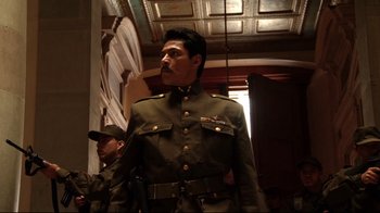 Movie still from “Once Upon a Time in Mexico” (2003), directed by Robert Rodriguez – A man in a military uniform standing next to another man; Medium shot, Low angle