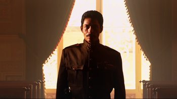 Movie still from “Once Upon a Time in Mexico” (2003), directed by Robert Rodriguez – A man in a uniform standing in front of a stained glass window; Medium shot, Low angle