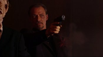 Movie still from “Once Upon a Time in Mexico” (2003), directed by Robert Rodriguez – A man holding a gun while wearing a black shirt; Close Up shot, Low angle