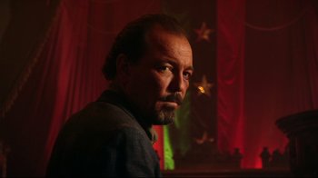 Movie still from “Once Upon a Time in Mexico” (2003), directed by Robert Rodriguez – A man with a goatee and beard in front of a red curtain; Close Up shot, Low angle