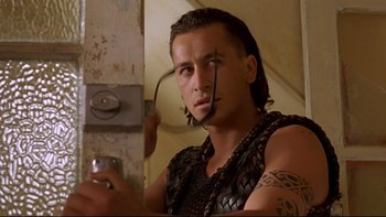 Movie still from “Once Were Warriors” (1994), directed by Lee Tamahori – A man in chains is holding a drink; Close Up shot, Low angle