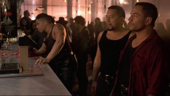 Movie still from “Once Were Warriors” (1994), directed by Lee Tamahori – A group of men standing around a table; Medium shot, Low angle