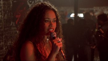 Movie still from “Once Were Warriors” (1994), directed by Lee Tamahori – A woman with curly hair is holding a microphone; Close Up shot, Over the shoulder angle