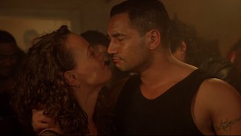 Movie still from “Once Were Warriors” (1994), directed by Lee Tamahori – A man and a woman are kissing in a room; Close Up shot, Over the shoulder angle
