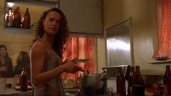 Movie still from “Once Were Warriors” (1994), directed by Lee Tamahori – A woman is cooking in the kitchen with a pan; Medium shot, Low angle