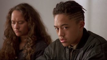 Movie still from “Once Were Warriors” (1994), directed by Lee Tamahori – A young man sitting in front of a young woman; Close Up shot, Over the shoulder angle