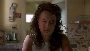 Movie still from “Once Were Warriors” (1994), directed by Lee Tamahori – A woman with a bruised eye sitting in a room; Close Up shot, Low angle