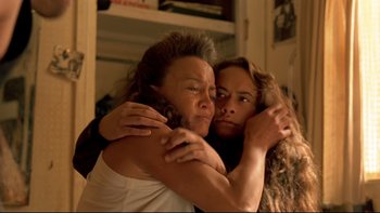 Movie still from “Once Were Warriors” (1994), directed by Lee Tamahori – Two women hugging each other in a living room; Close Up shot, High angle