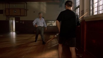 Movie still from “Once Were Warriors” (1994), directed by Lee Tamahori – Two men are playing a game with a wooden stick; Wide shot, Low angle