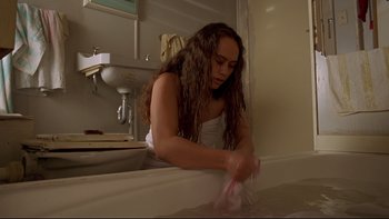 Movie still from “Once Were Warriors” (1994), directed by Lee Tamahori – A woman in a white shirt is washing her hands; Medium shot, High angle