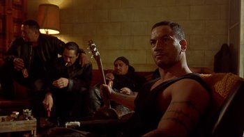 Movie still from “Once Were Warriors” (1994), directed by Lee Tamahori – A group of men sitting on a couch; Medium shot, Low angle