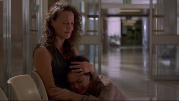 Movie still from “Once Were Warriors” (1994), directed by Lee Tamahori – A woman sitting next to another woman in a room; Medium shot, Over the shoulder angle