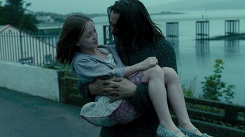 Movie still from “Ondine” (2009), directed by Neil Jordan – A woman holding a little girl in her arms; Medium shot, Low angle