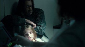 Movie still from “Ondine” (2009), directed by Neil Jordan – A man is combing a young girl's hair; Medium shot, Over the shoulder angle