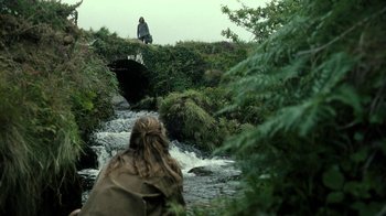 Movie still from “Ondine” (2009), directed by Neil Jordan – A person standing on a bridge over a river; Wide shot, Over the shoulder angle