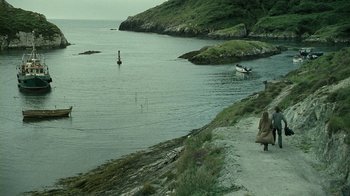 Movie still from “Ondine” (2009), directed by Neil Jordan – Two people sitting on the shore of a body of water; Extreme Wide shot, High angle