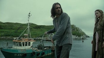 Movie still from “Ondine” (2009), directed by Neil Jordan – A man standing next to a boat in the water; Medium shot, Low angle