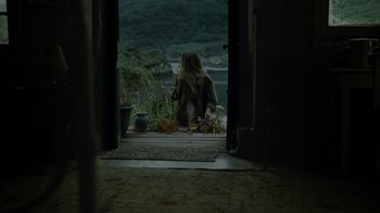Movie still from “Ondine” (2009), directed by Neil Jordan – A woman sitting on a porch looking out at the water; Wide shot, Over the shoulder angle