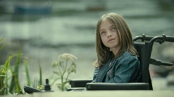 Movie still from “Ondine” (2009), directed by Neil Jordan – A young girl sitting in a wheelchair looking into the distance; Medium shot, High angle