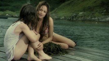 Movie still from “Ondine” (2009), directed by Neil Jordan – Two women sitting on a dock next to a body of water; Medium shot, Over the shoulder angle